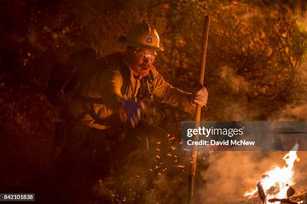 Firefighter fights flames in chaparral brush using only a hand tool at the La Tuna Fire on September 2, 2017 near Burbank, California. Los Angeles...