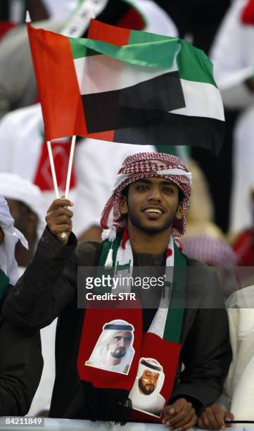 An Emirati football fan waves a national as he supports his team during a 19th Gulf Cup football match against Qatar in Muscat on January 8, 2009....