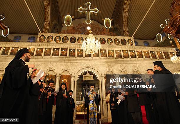 Syrian Christian priests carry candles as they attend prayers for the Palestinians killed in Gaza lead by Christian Orthodox Patriarch of Antioch and...