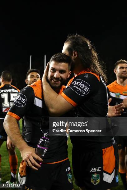 Aaron Woods of the Tigers embraces team mate James Tedesco of the Tigers after winning the round 26 NRL match between the Wests Tigers and the New...