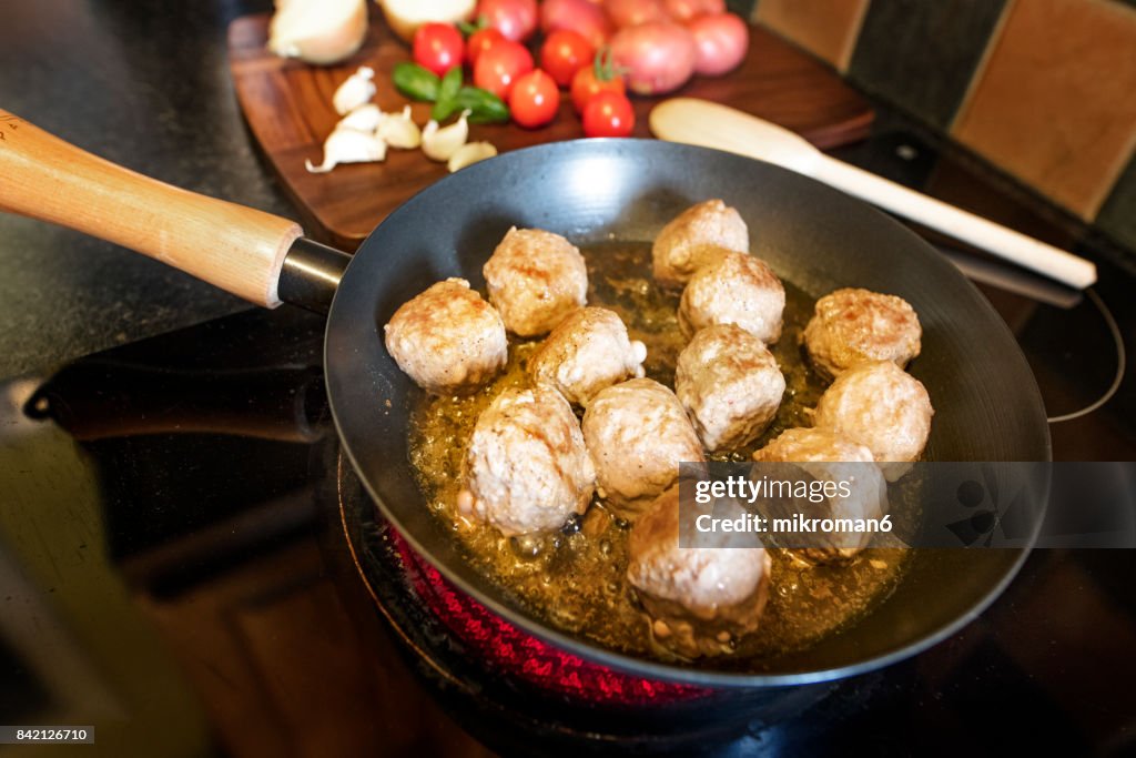 Close-Up Of Meatballs In frying pan on hot Electric Hob