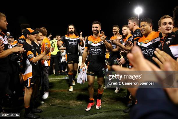 James Tedesco and Aaron Woods of the Tigers are applauded off the field after playing their final game for the Tigers during the round 26 NRL match...