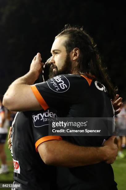 Aaron Woods of the Tigers embraces team mate James Tedesco following the round 26 NRL match between the Wests Tigers and the New Zealand Warriors at...