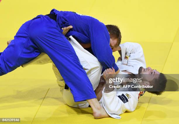 France's Axel Clerget competes with Germany's Marc Odenthal in their -90kg match of the team event at the World Judo Championships in Budapest on...