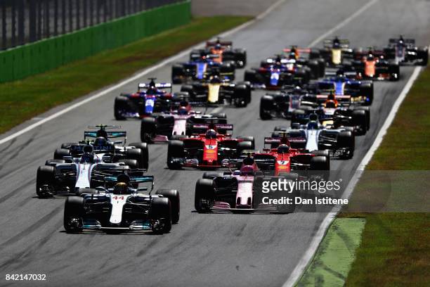 Lewis Hamilton of Great Britain driving the Mercedes AMG Petronas F1 Team Mercedes F1 WO8 leads the field into the first corner at the start during...