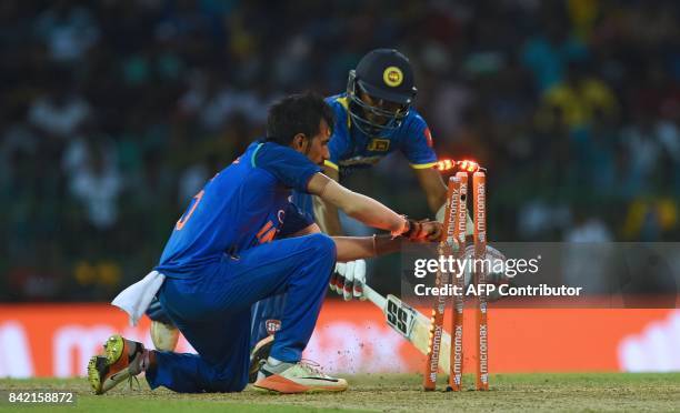 Sri Lankan cricketer Wanindu Hasaranga is run out by Indian cricketer Yuzvendra Chahal during the final one day international cricket match between...