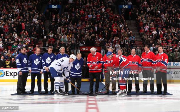 Alexei Kovalev of the Montreal Canadiens and Tomas Kaberle the Toronto Maple Leafs take a ceremonial faceoff with Johnny Bower, Jean Beliveau and...