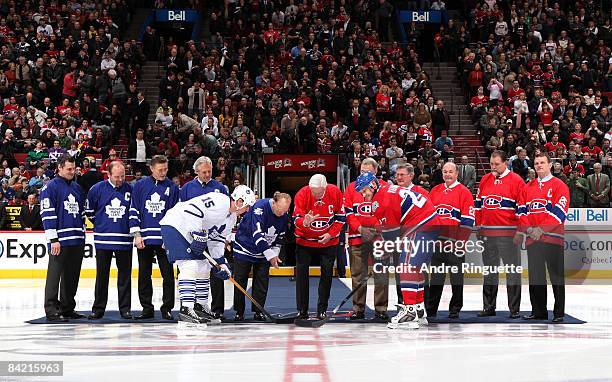 Alexei Kovalev of the Montreal Canadiens and Tomas Kaberle the Toronto Maple Leafs take a ceremonial faceoff with Johnny Bower, Jean Beliveau and...