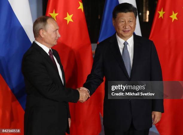 Russian President Vladimir Putin shakes hands with Chinese President Xi Jinping during his meeting in Xiamen, China, September 2017. Leaders of...