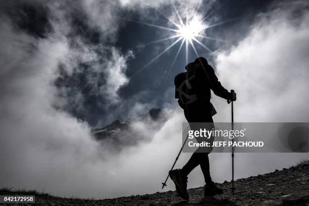An ultra-trailer walks in La Flegere path on September 3, 2017 near Chamonix, as he competes during the 15th edition of the Mount Blanc Ultra Trail ,...