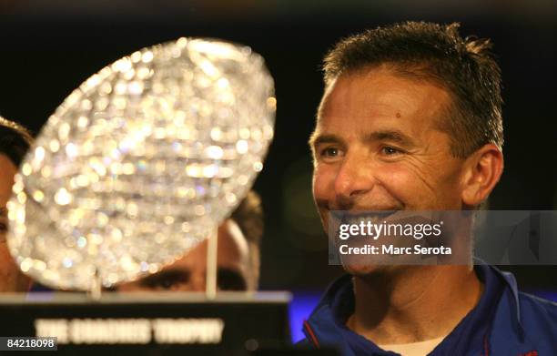 Urban Meyer of the Florida Gators smiles as he is presented with the National Championship trophy after their 24-14 win against the Oklahoma Sooners...