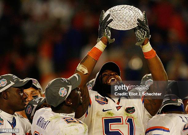 Brandon Spikes of the Florida Gators celebrate with the trophy after defeating the Oklahoma Sooners in the FedEx BCS National Championship Game at...