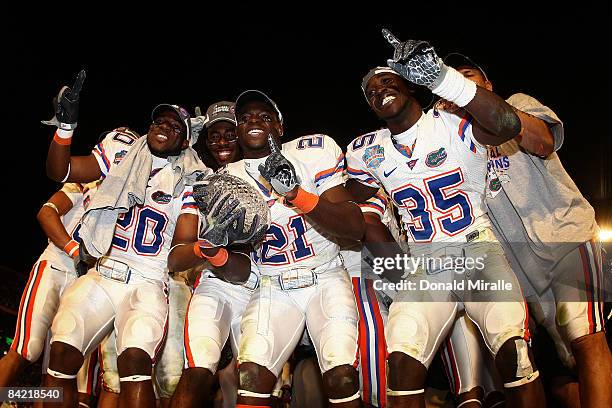 Dorian Munroe, Major Wright and Ahmad Black of the Florida Gators celebrate with the trophy after defeating the Oklahoma Sooners in the FedEx BCS...
