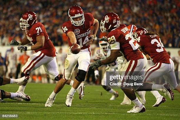 Sam Bradford of the Oklahoma Sooners hands the ball off to Chris Brown against the Florida Gators during the FedEx BCS National Championship game at...