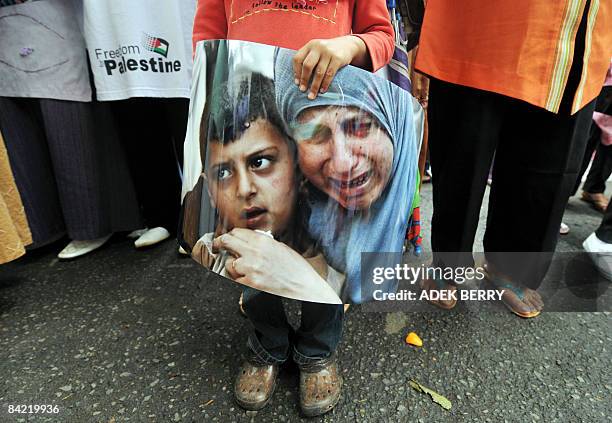 Young girl holds a photo showing a Palestianian mother and her child during a protest in front of the Egyptian embassy in Jakarta on January 9, 2009...