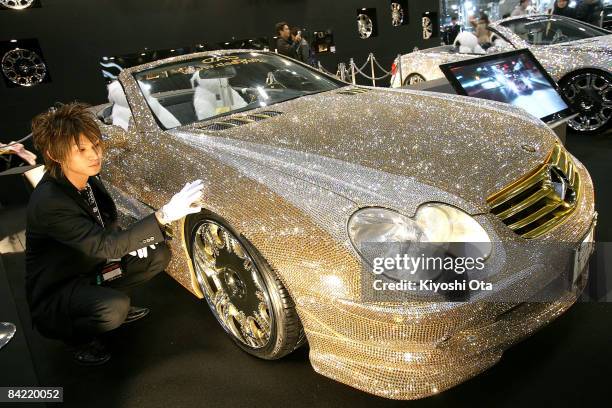 An exhibitor polishes a 'Luxury Crystal Benz', the customized Mercedes-Benz SL600 with 300,000 Swarovski crystals, displayed at a booth at Tokyo Auto...