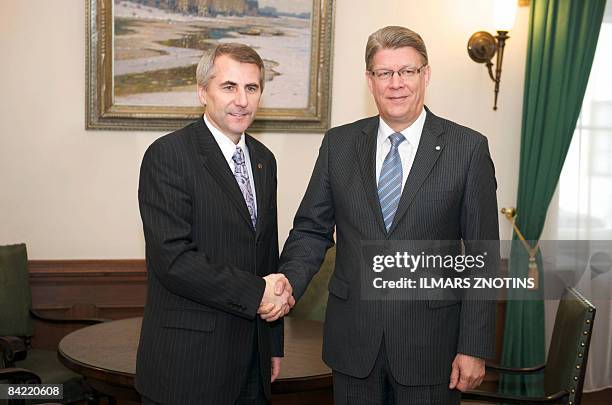 Latvian President Valdis Zatlers greets Lithuanian Foreign Minister Vygaudas Usackas on January 9, 2009 before their meeting in Riga. Facing...
