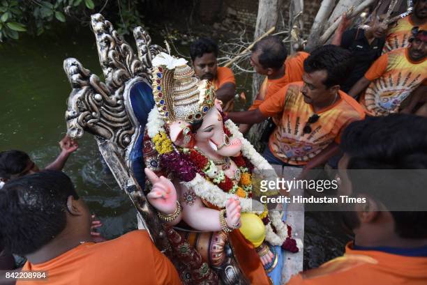 Devotees during the tenth day immersion of Ganesha idols at Sukhrali pond, on September 3, 2017 in Gurgaon, India. Several devotees, who brought the...
