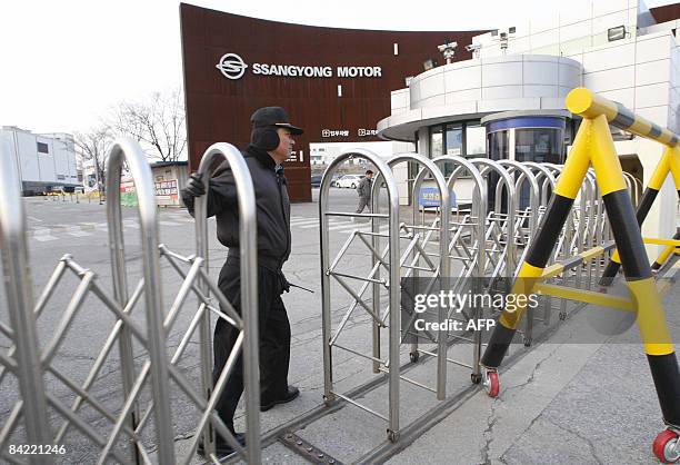 Guyard closes the gate at Ssangyong Motor factory in Pyeongtaek, south of Seoul on January 9, 2009. Chinese-owned Ssangyong Motor of South Korea, hit...