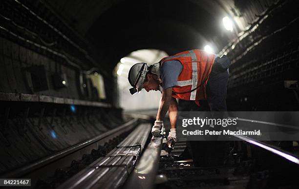 Worker cleans the ceramic insulator pots under the live rail near Pimlico Underground Station on October 6, 2008 in London. A team of four cleaners...