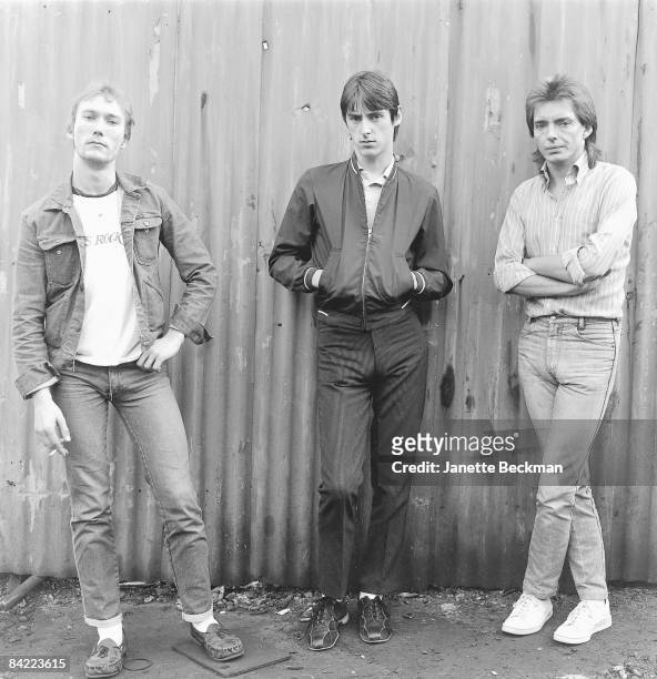 Rock musicians Rick Buckler, Paul Weller, and Bruce Foxton of the band The Jam pose outdoors in London, 1979.
