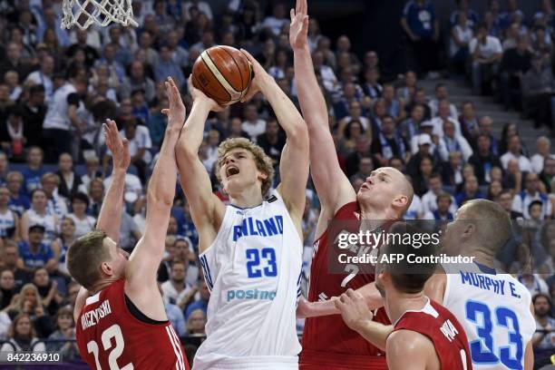 Lauri Markkanen of Finland goes up for the basket between Adam Waczynski , Damian Kulig and Mateusz Ponitka of Poland and Erik Murphy of Finland...