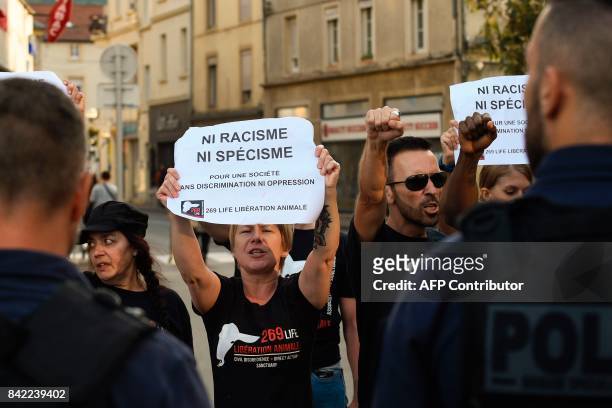 Members of the animal protection association "269 Life Liberte Animale" face police officers as they demonstrate at the start of a speech by...