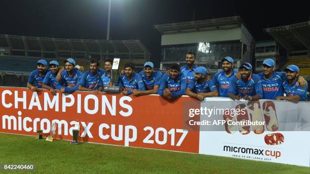 Indian cricket team players pose with the trophy after their win over Sri Lanka in the fifth and last one-day international cricket match between Sri...