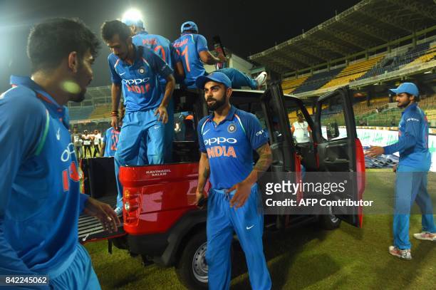 India's cricket team including captain Virat Kohli celebrate on a truck while driving it around the ground after winning the match and the series...