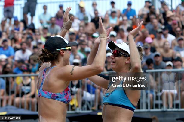 Lauren Fendrick and April Ross celebrate after winning a point during their match against Kelly Claes and Sara Hughes in the semifinal round at the...