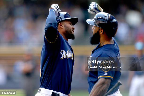 Domingo Santana of the Milwaukee Brewers celebrates with Eric Thames after hitting a solo homer during the second inning against the Washington...