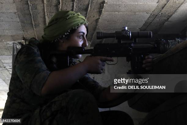 Female member of the Syrian Democratic Forces , a US backed Kurdish-Arab alliance, holds a position inside a building in an area close to the Old...
