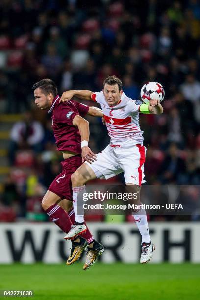 Stephan Lichtsteiner of Switzerland competes with Vitalijs Maksimenko of Latvia during the FIFA 2018 World Cup Qualifier between Latvia and...