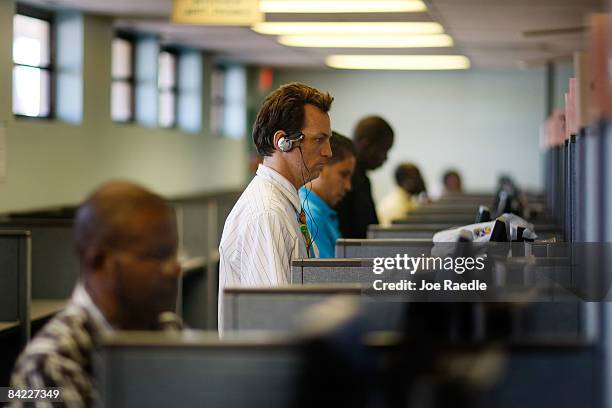 Billy Green who lost his job as a customer care representative five months ago and other unemployed people look through a computer database for a new...