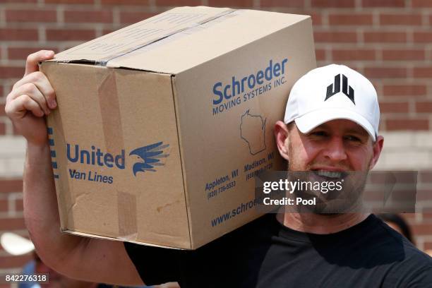 Houston Texans defensive end J.J. Watt holds a box of relief supplies on his shoulder while handing them out to people impacted by Hurricane Harvey...