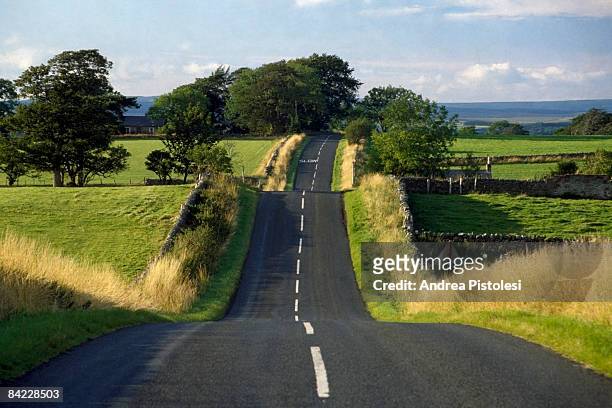road in english coutryside - bumpy stockfoto's en -beelden