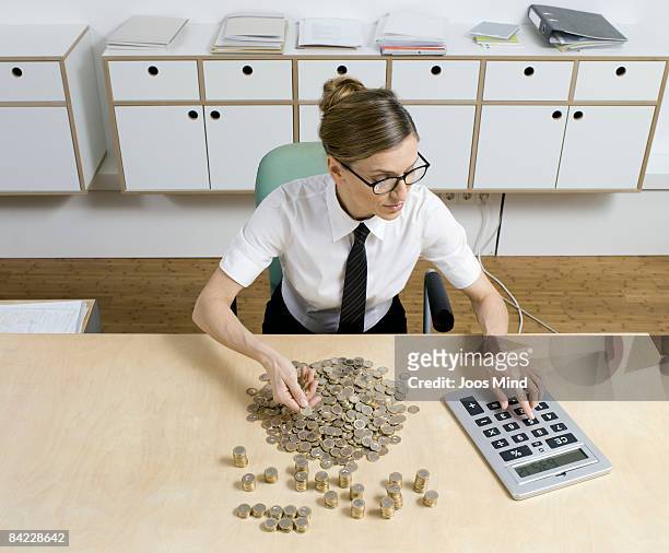 businesswoman counting money, using calculator - bureau de change stockfoto's en -beelden