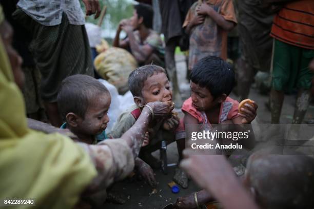 Grpup of Rohingya Muslims, fled from ongoing military operations in Myanmars Rakhine state eat food after crossing the Bangladesh-Myanmar border...