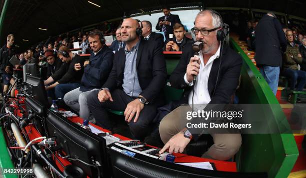 Nick Mullins, the BT Sport rugby commentator watches the match with pundits Lawrence Dallaglio and Austin Healey during the Aviva Premiership match...