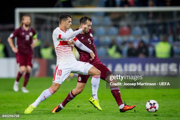 Granit Xhaka of Switzerland competes with Olegs Laizans of Latvia during the FIFA 2018 World Cup Qualifier between Latvia and Switzerland at Skonto...