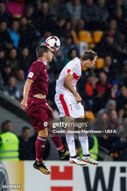 Olegs Laizans of Latvia competes with Stephan Lichtsteiner of Switzerland during the FIFA 2018 World Cup Qualifier between Latvia and Switzerland at...