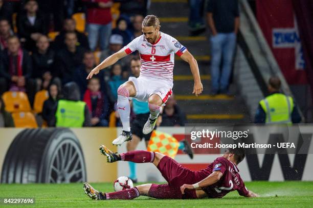 Michael Lang of Switzerland is tackled by Vitalijs Maksimenko of Latvia during the FIFA 2018 World Cup Qualifier between Latvia and Switzerland at...