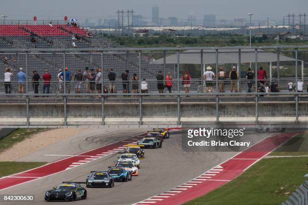 Fans watch from a bridge as cars race underneath them during the Pirelli World Challenge GT race at Circuit of The Americas on September 3, 2017 in...