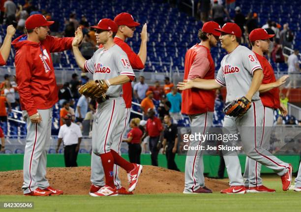 Hyun Soo Kim and Ty Kelly of the Philadelphia Phillies celebrate with teammates after their 12-inning 3-1 win over the Miami Marlins at Marlins Park...