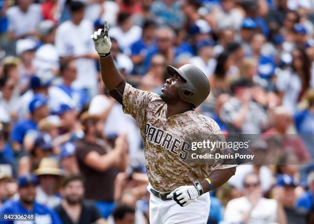 Jose Pirela of the San Diego Padres points skyward after hitting a solo home run during the fifth inning of a baseball game against the Los Angeles...