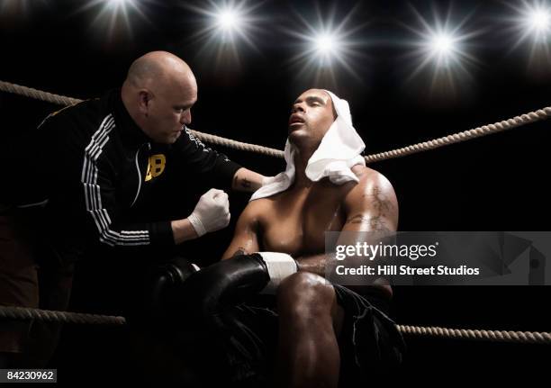 trainer talking to african boxer in ring - boxing coach stock pictures, royalty-free photos & images