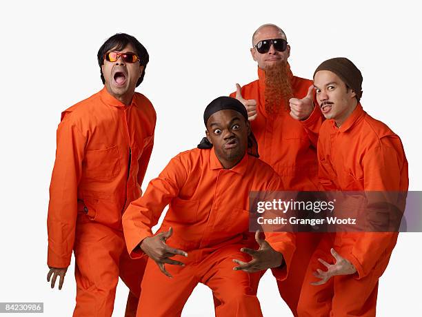 multi-ethnic criminals in prison uniforms - prison jumpsuit stock pictures, royalty-free photos & images