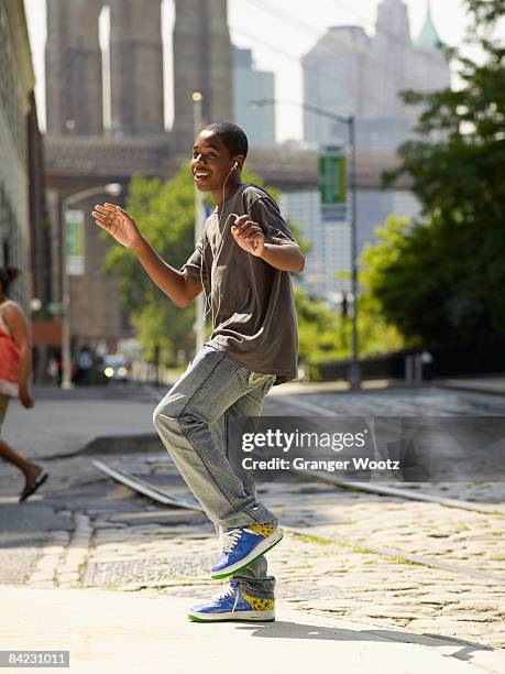 african boy dancing to music in urban setting - boy ipod stock pictures, royalty-free photos & images