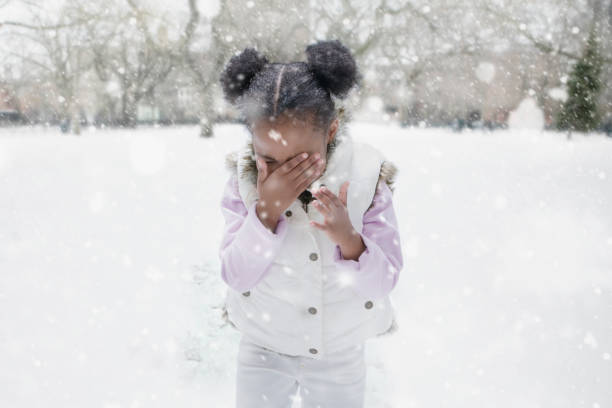 mixed race girl playing outdoors in falling snow - crying in the snow stock pictures, royalty-free photos & images