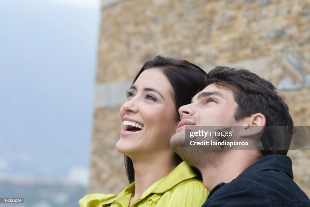 Curious Hispanic couple looking up